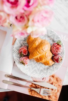 Croissant on a plate near with strawberies