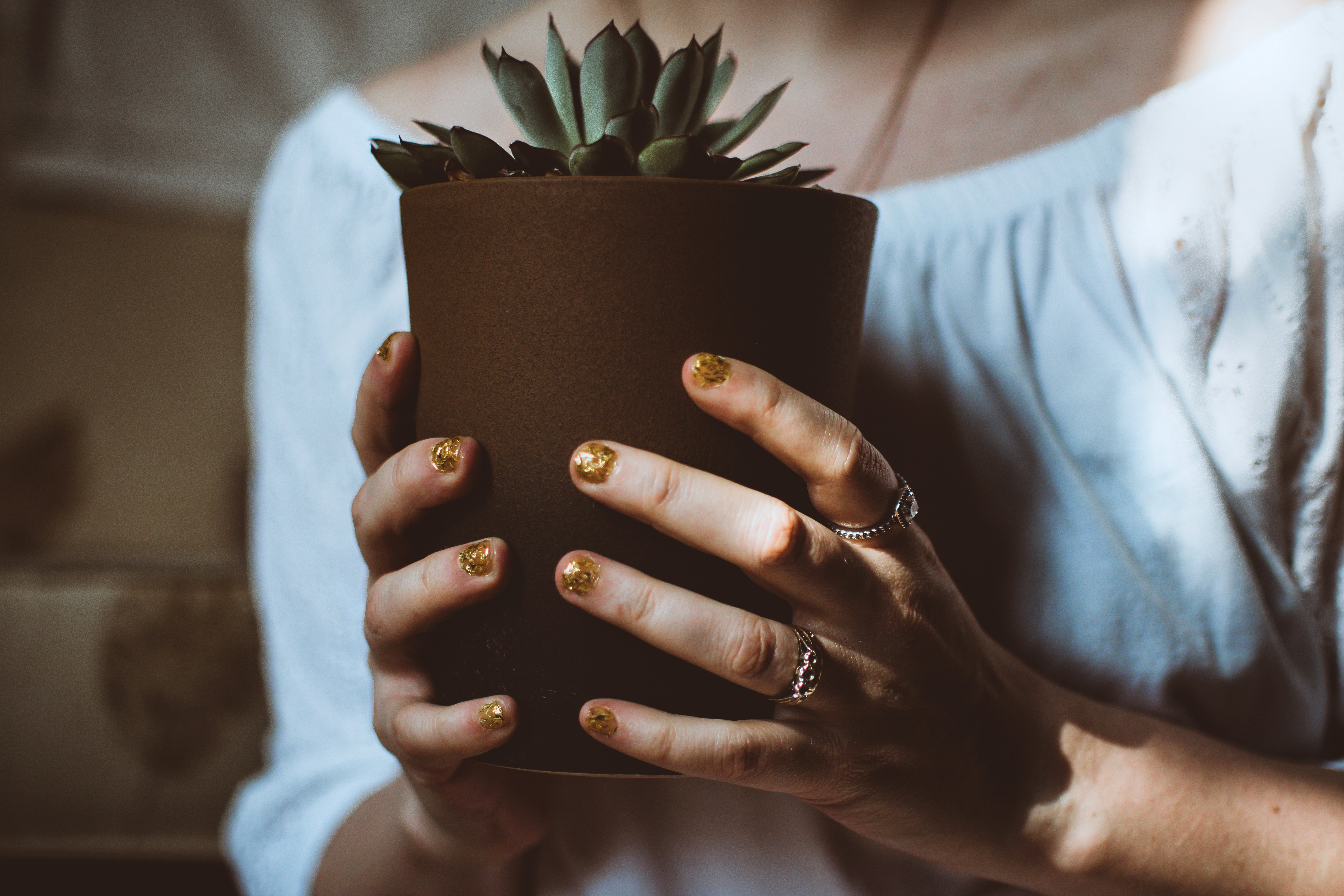 A person holding a brown plant pot
