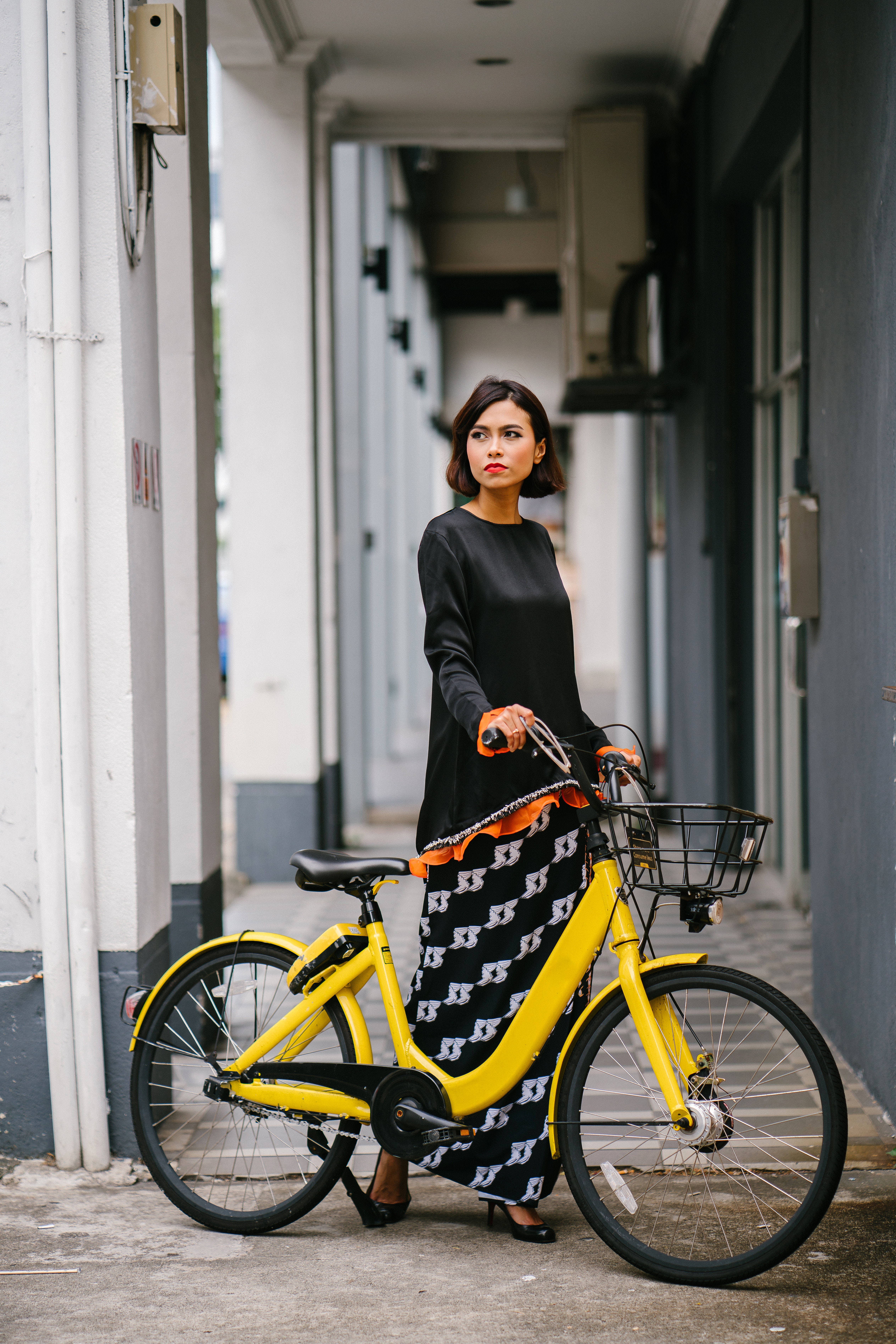A woman holding a yellow bike at daytime