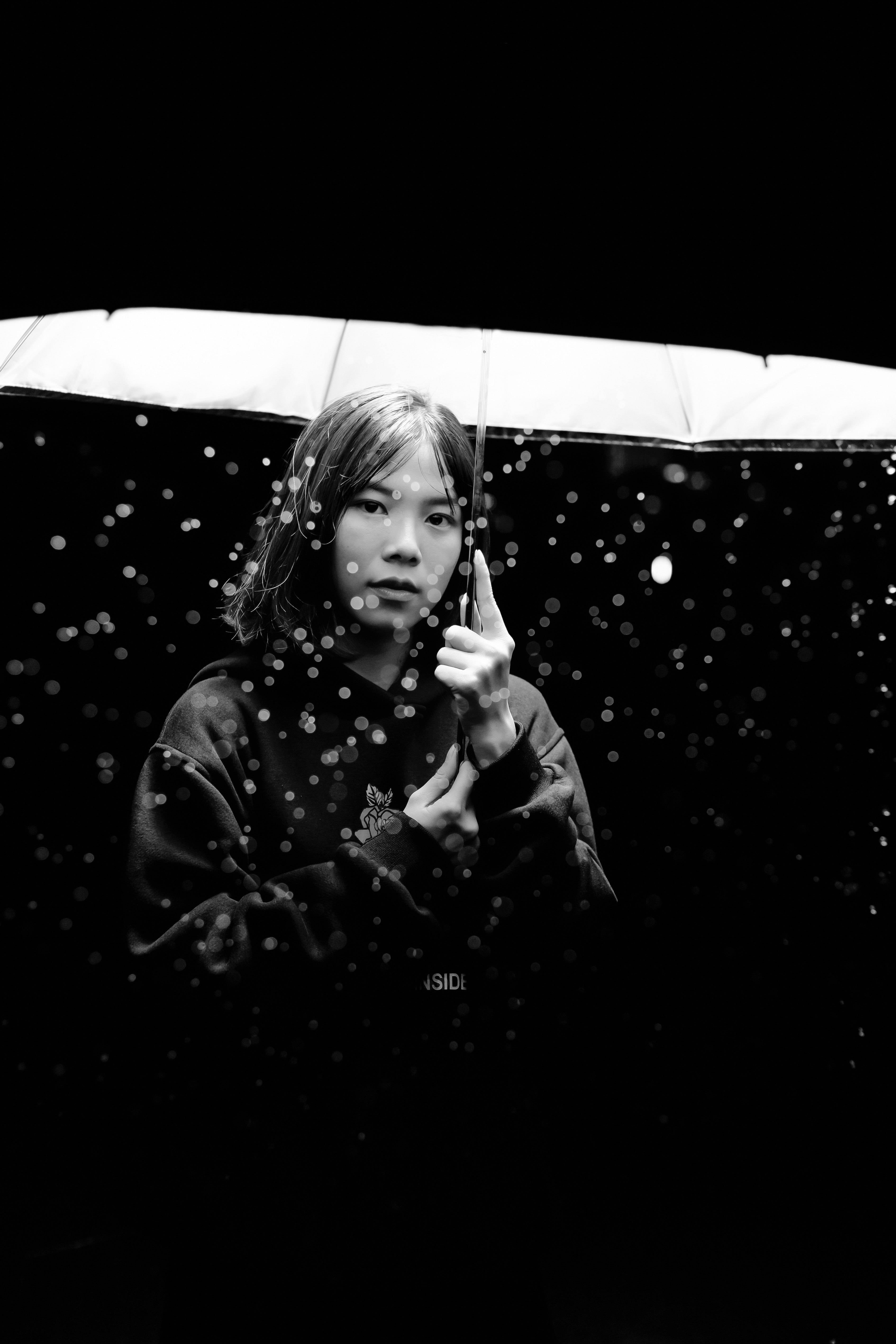 Black and white photography of a woman holding an umbrella