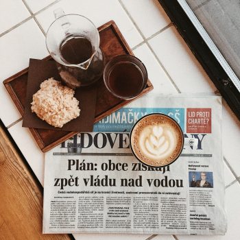 Breakfast with a cup of cappuccino standing on a newspaper