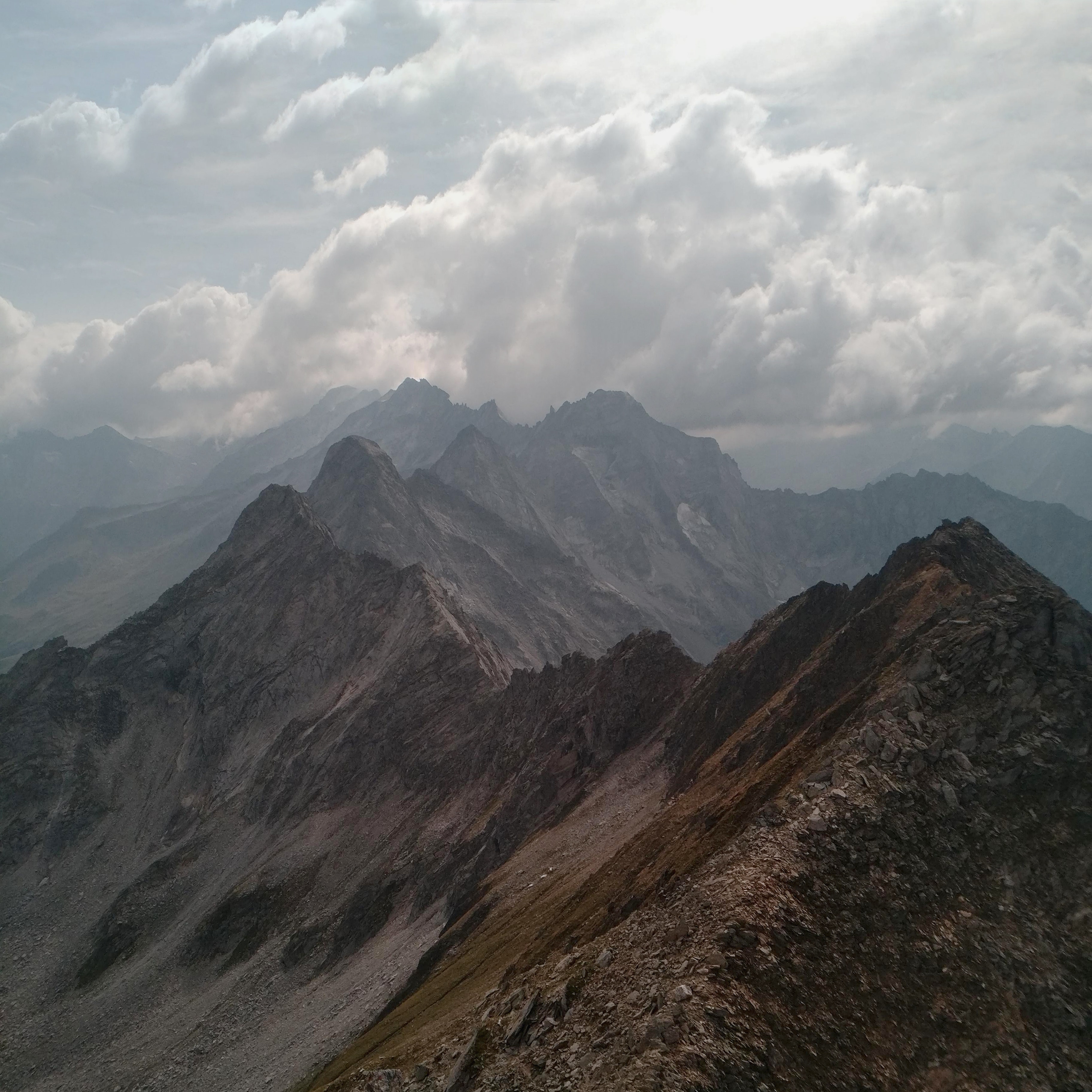 Brown and gray mountains under a cloudy sky
