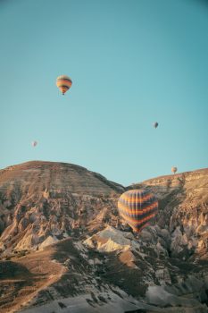 Hot air balloons floating above mountains