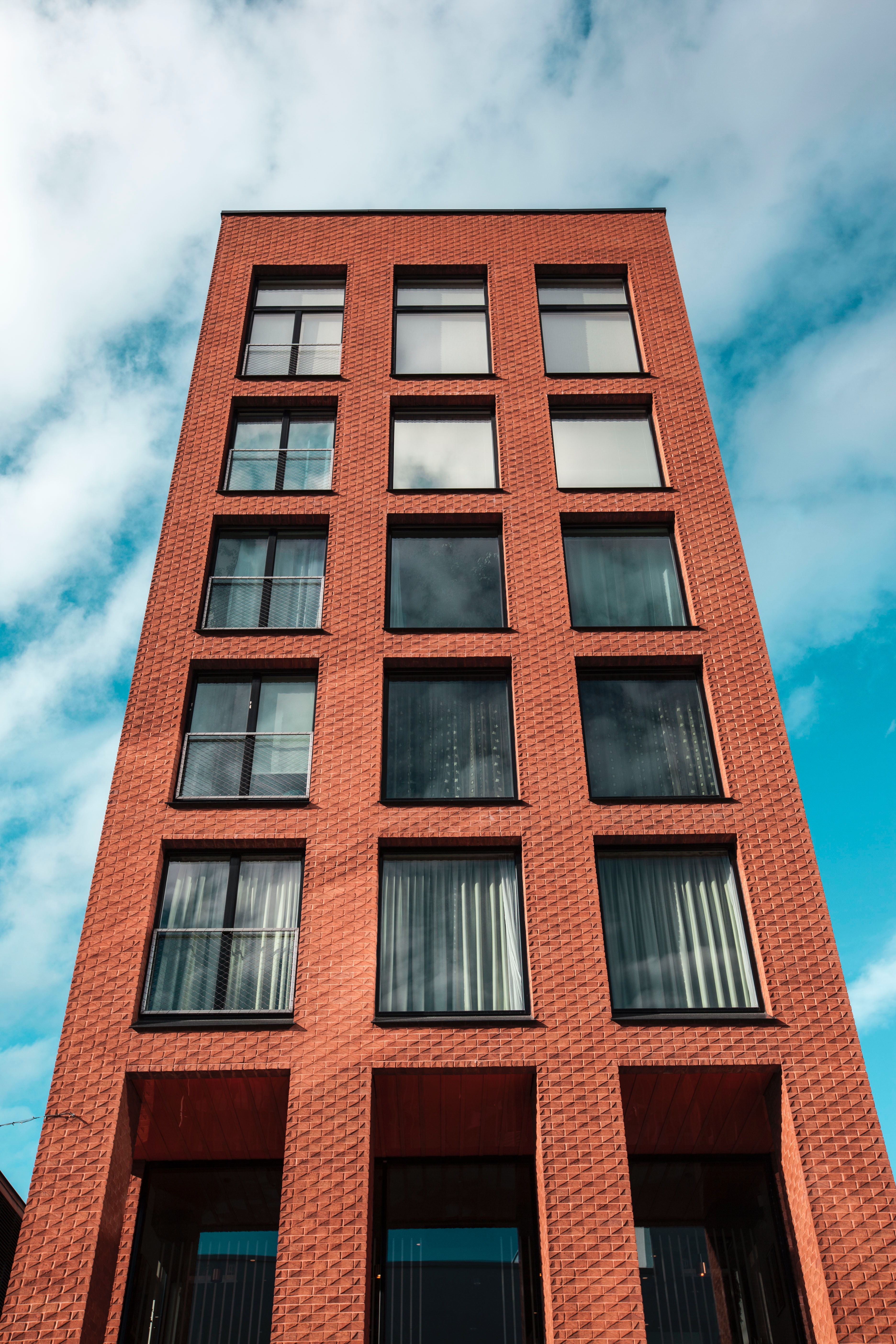 Low angle photo of a red and black concrete high-rise building
