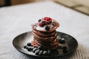 Pancakes with blueberries on a black plate