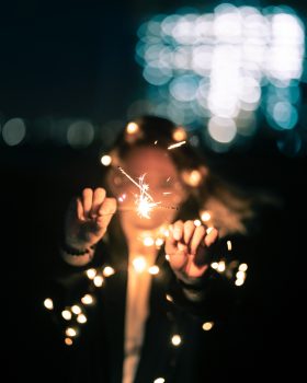 Selective focus photo of a woman holding sparklers