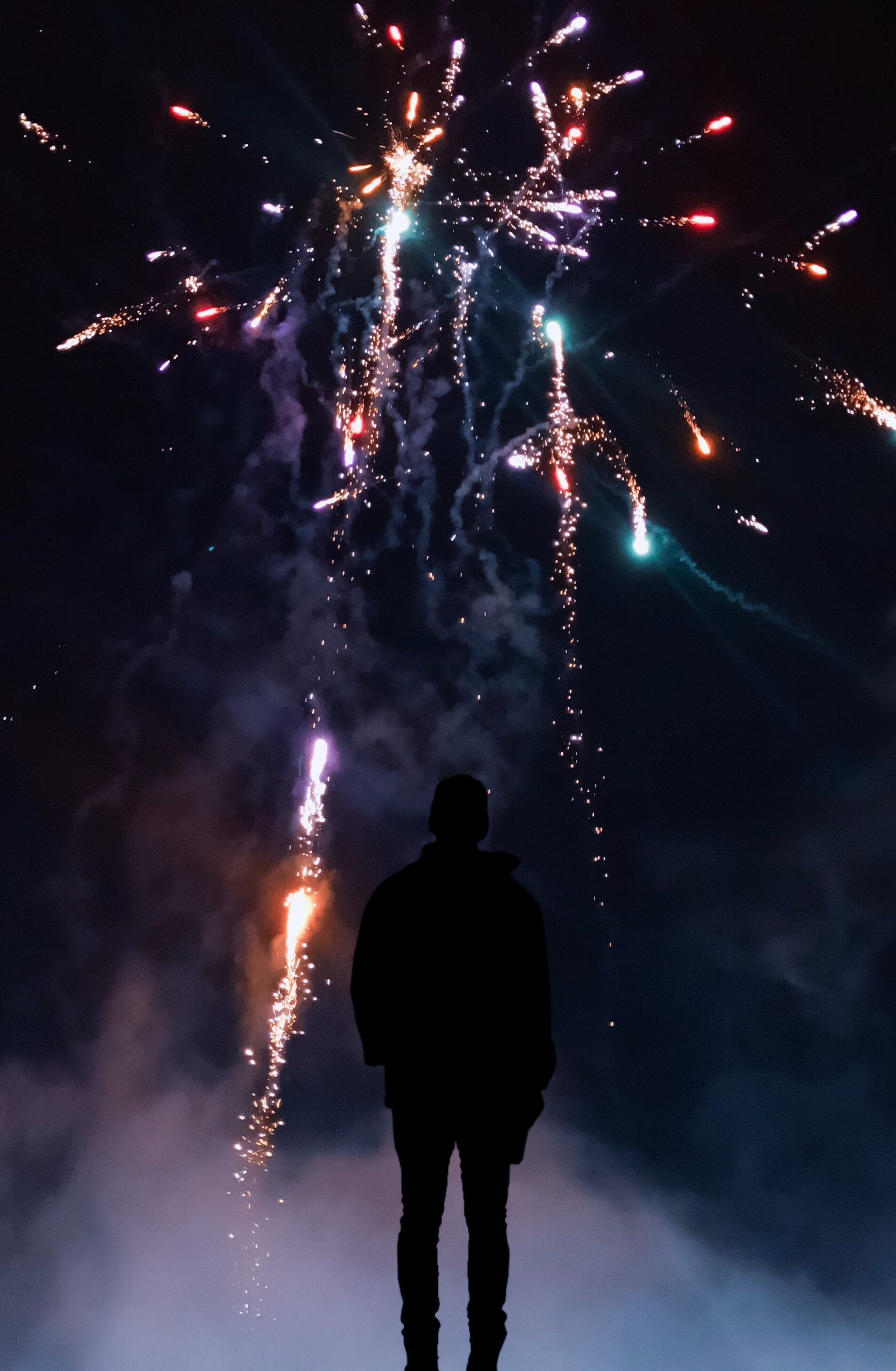 Silhouette of a person in front of fireworks
