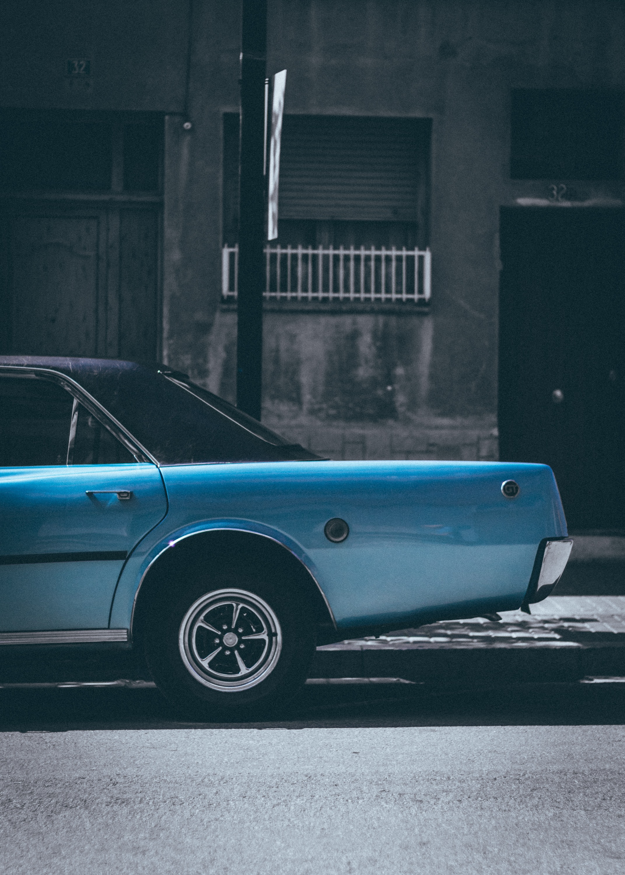 A classic blue sedan parked on the roadside