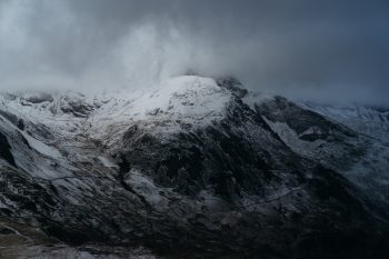 A snow-coned mountain under a cloudy sky