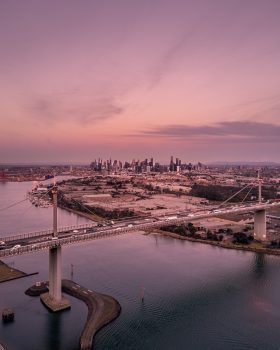 Aerial photography of city buildings and bridge during sunset