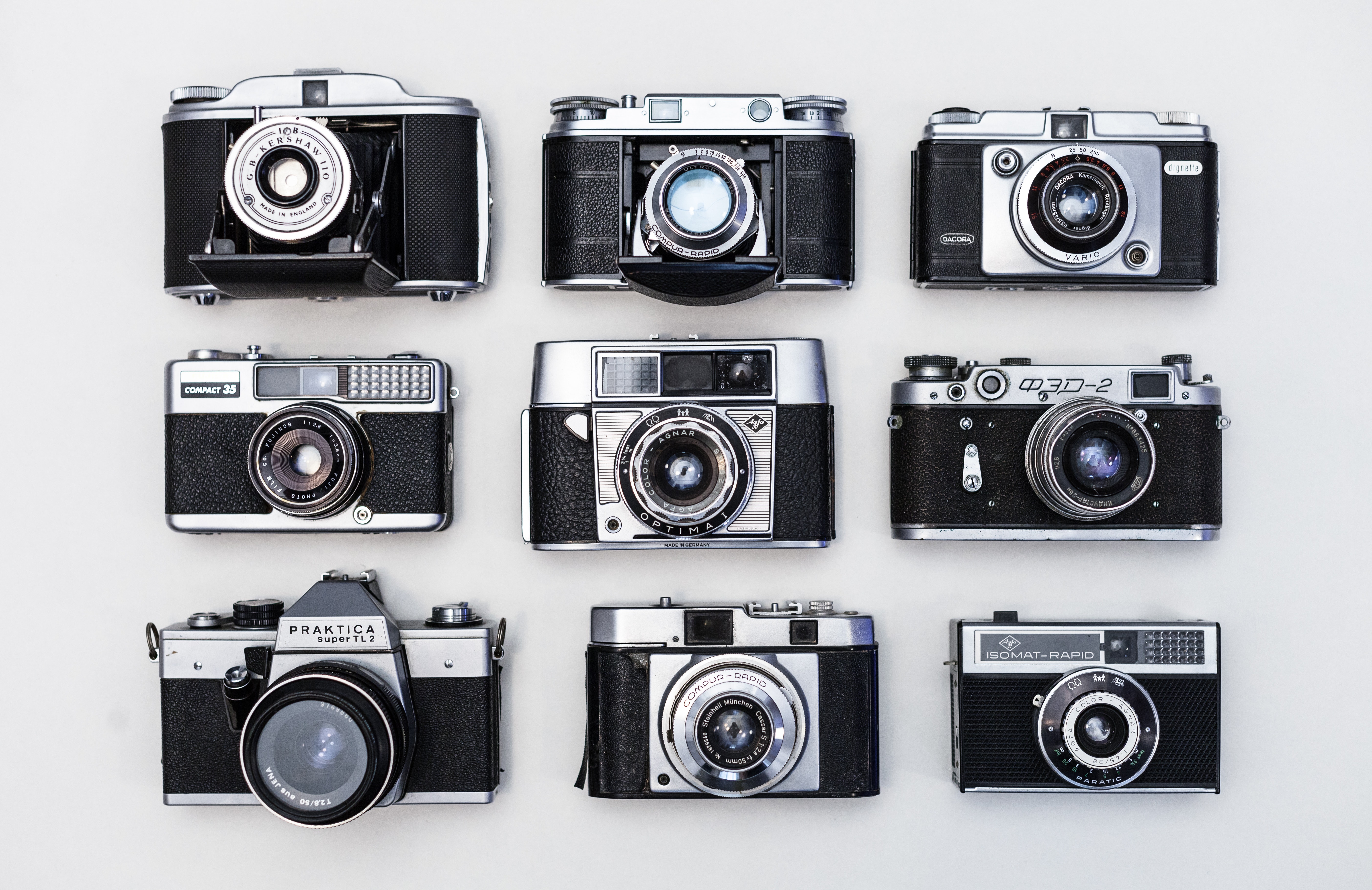 Flat lay photo of nine black-and-gray cameras
