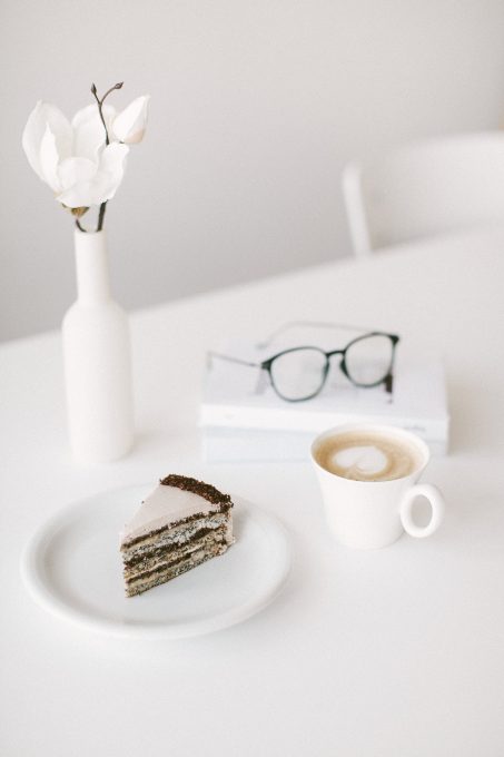Minimalist photo of a cup of coffee and a slice of cake lying on a plate