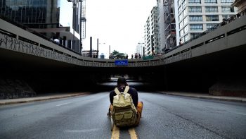 Photo of a man sitting in the middle of the road