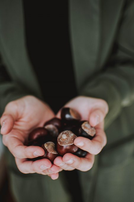 Photo of a person holding chestnuts