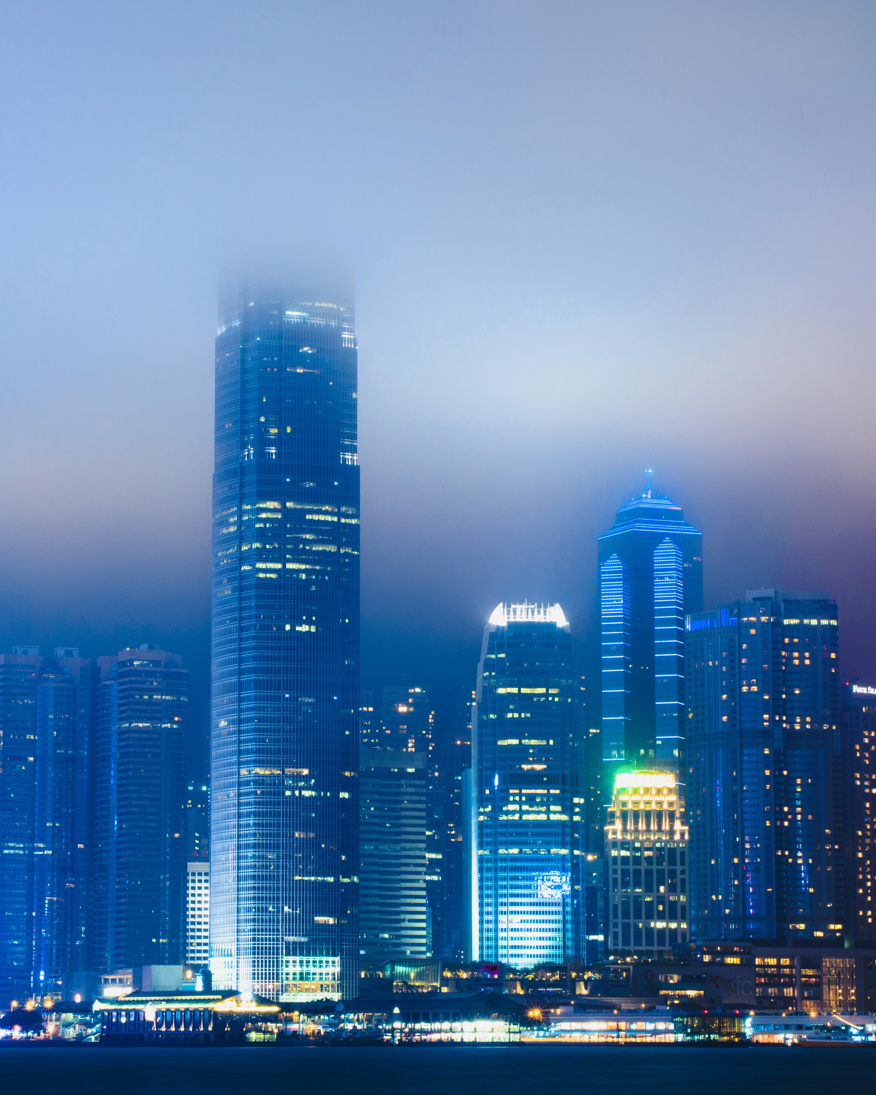 Scenic view of skyscrapers during a foggy evening