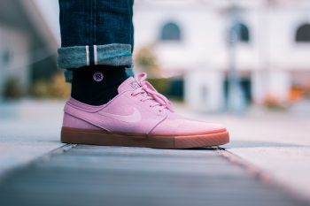 Selective focus photo of a person wearing pink Nike low-top sneakers