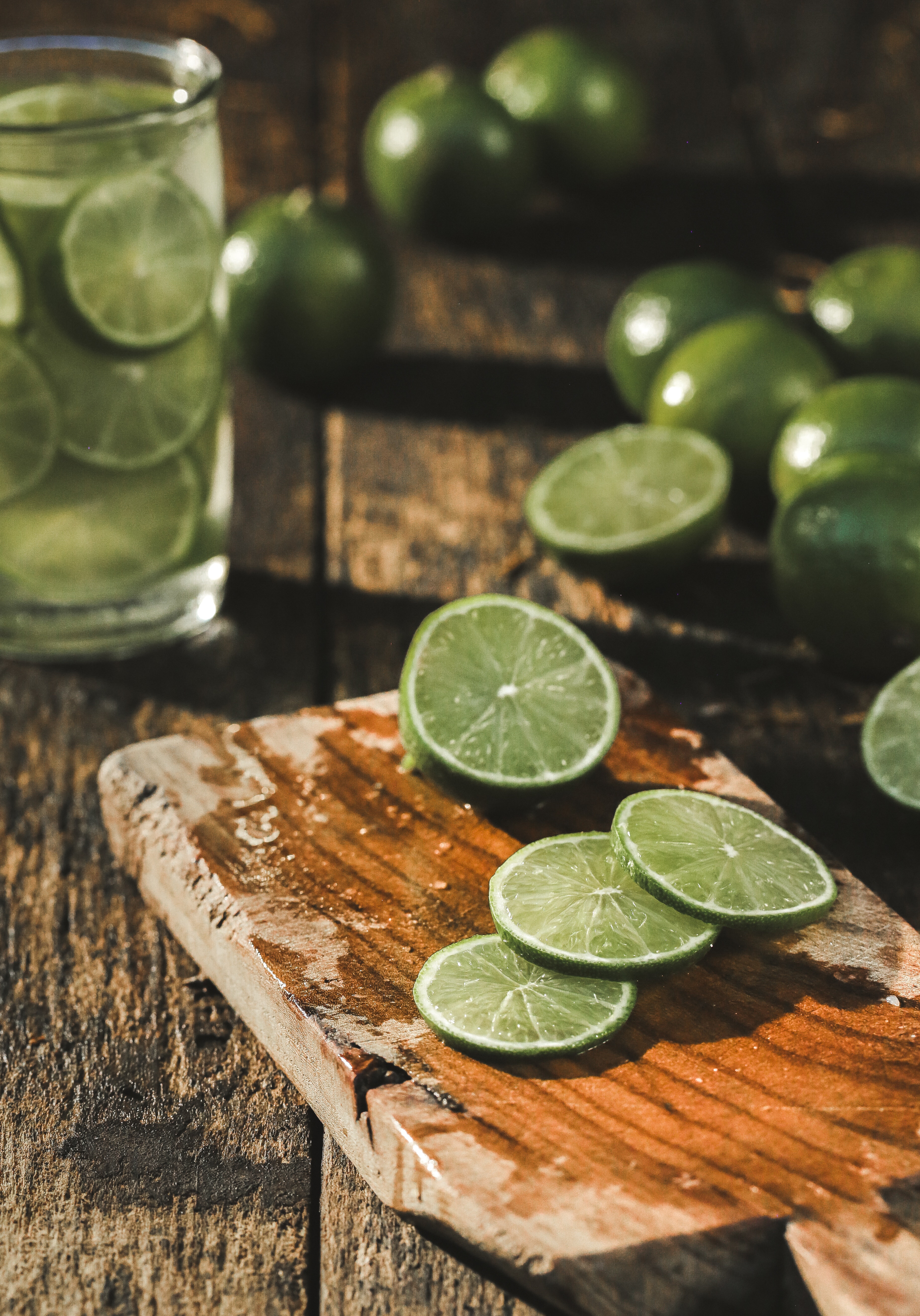 Slices of limes on a brown wood chopper