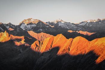 Sunlight illuminating mountain peaks during sunset
