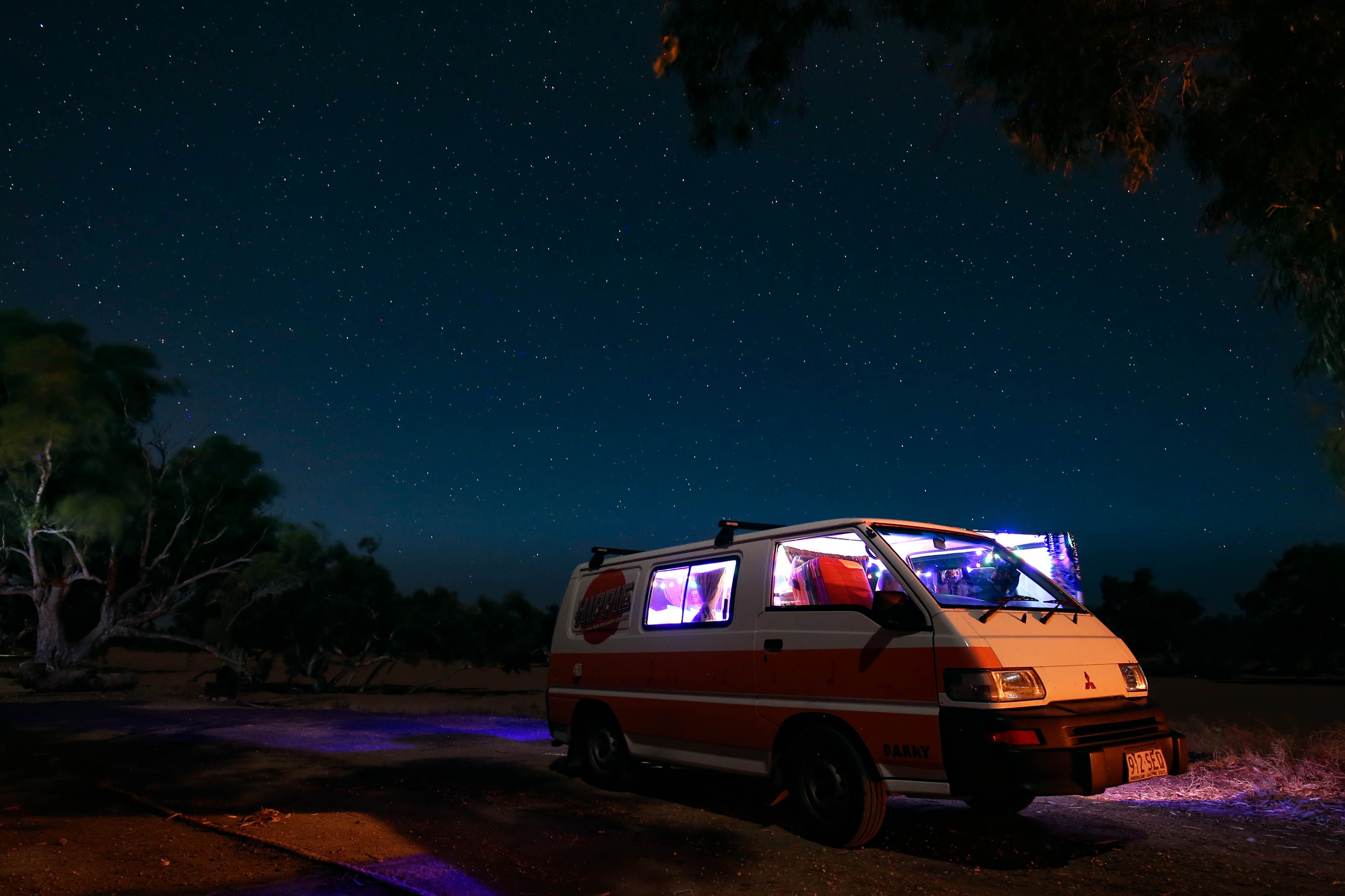 White and orange Mitsubishi Van during a starry night