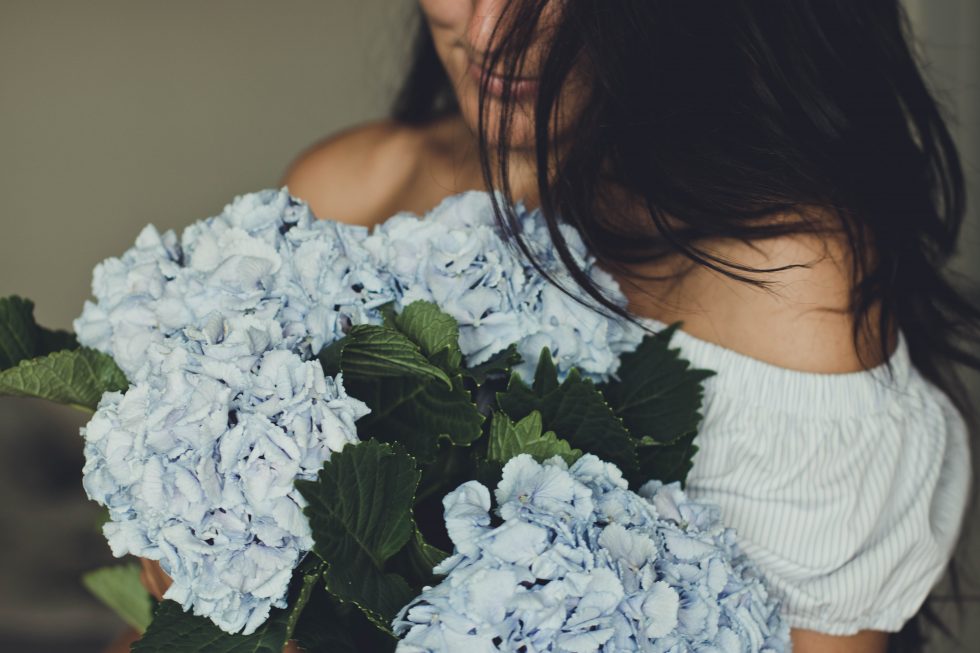 A woman holding blue flowers