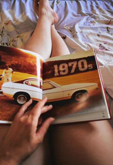 A person holding a car book on his lap