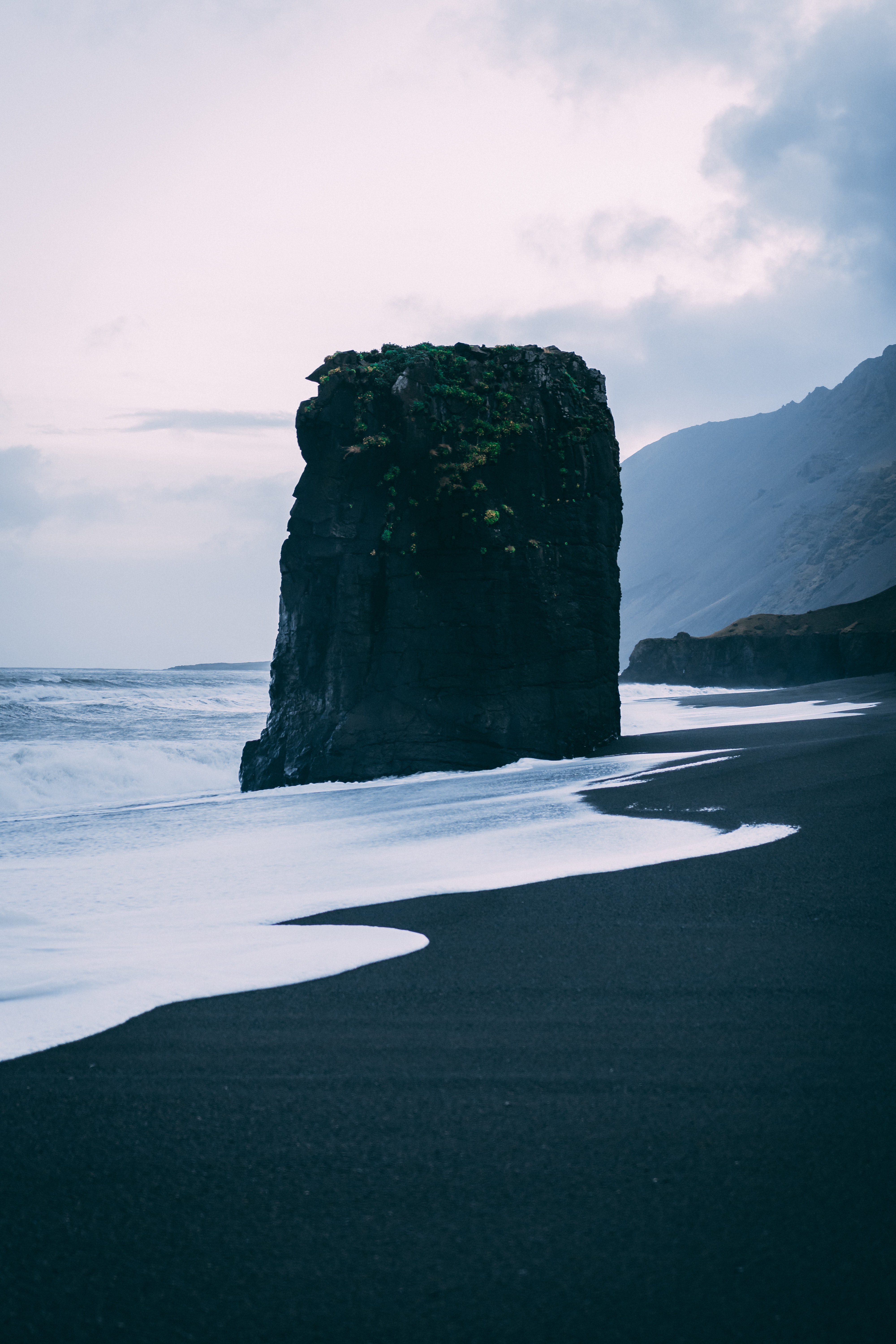A black rock formation near the sea