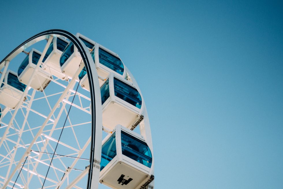 A blue and white Ferris wheel under a blue sky