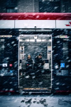 A man beside a woman in a train during snowfall