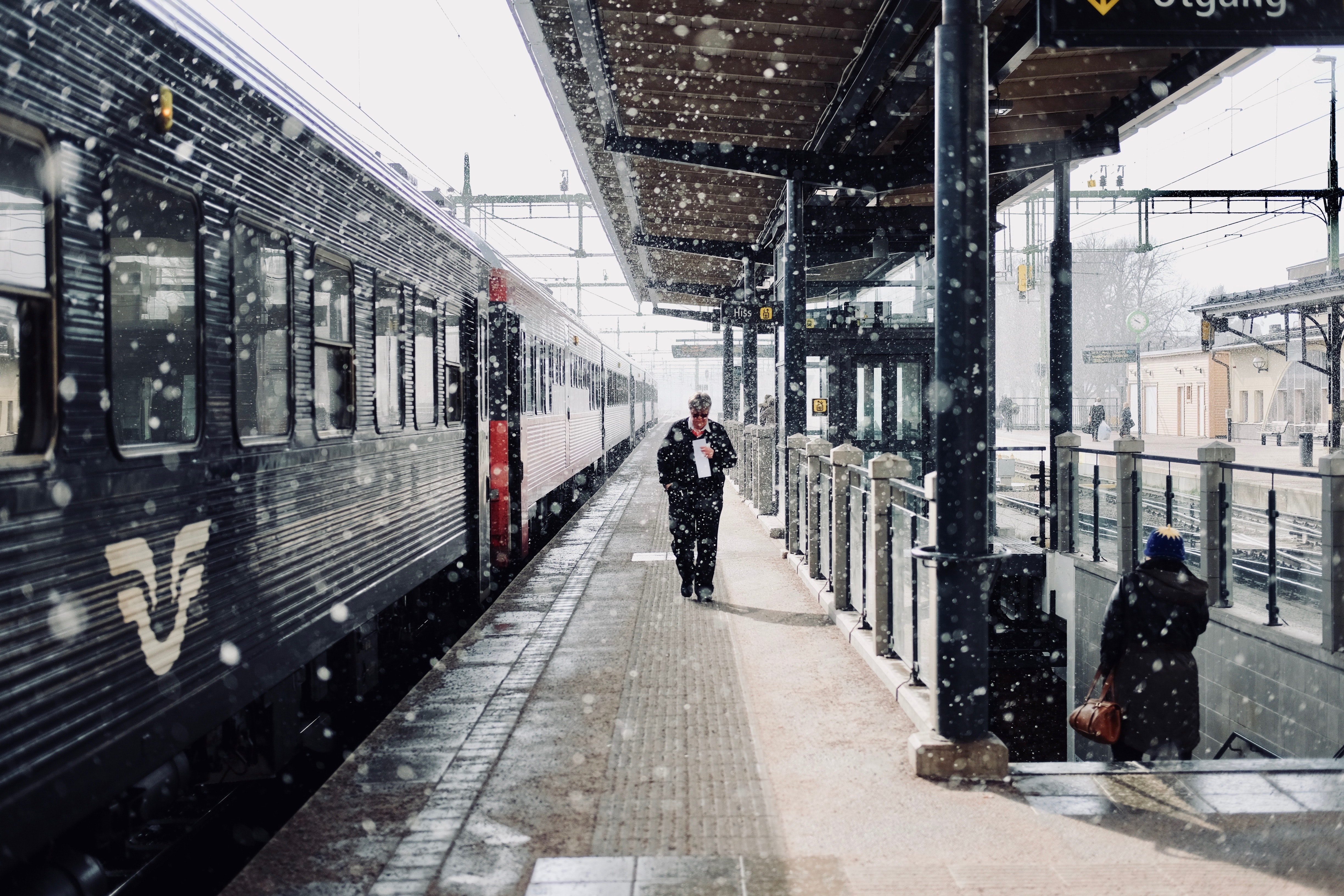 A man walking beside a train during snowfall