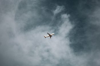 A white plane on air under a cloudy sky