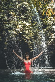 A woman in a red bathing suit splashing water