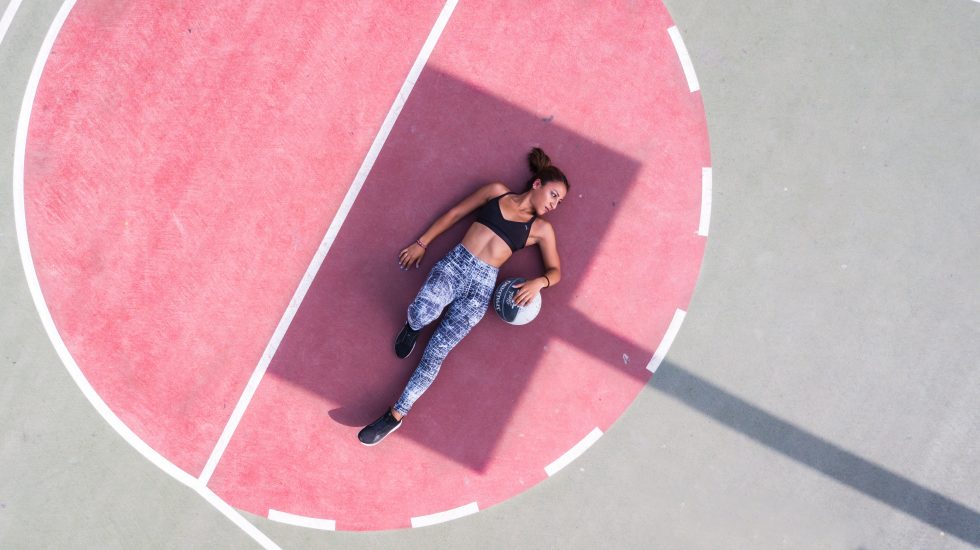 A woman lying on a basketball court