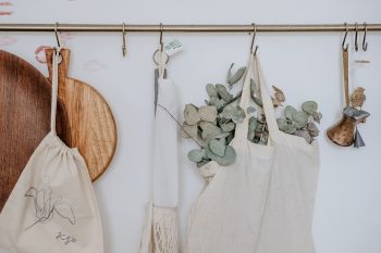 Aprons, a chopping board, and bag hanging on a white painted wall