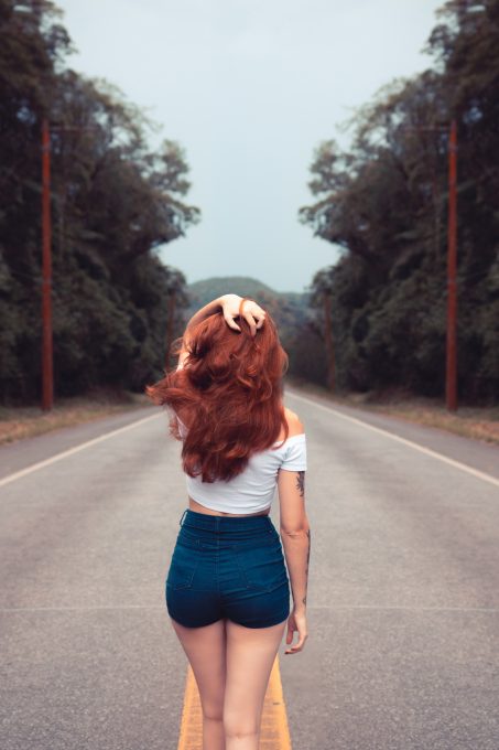 Back view of a woman standing on a road