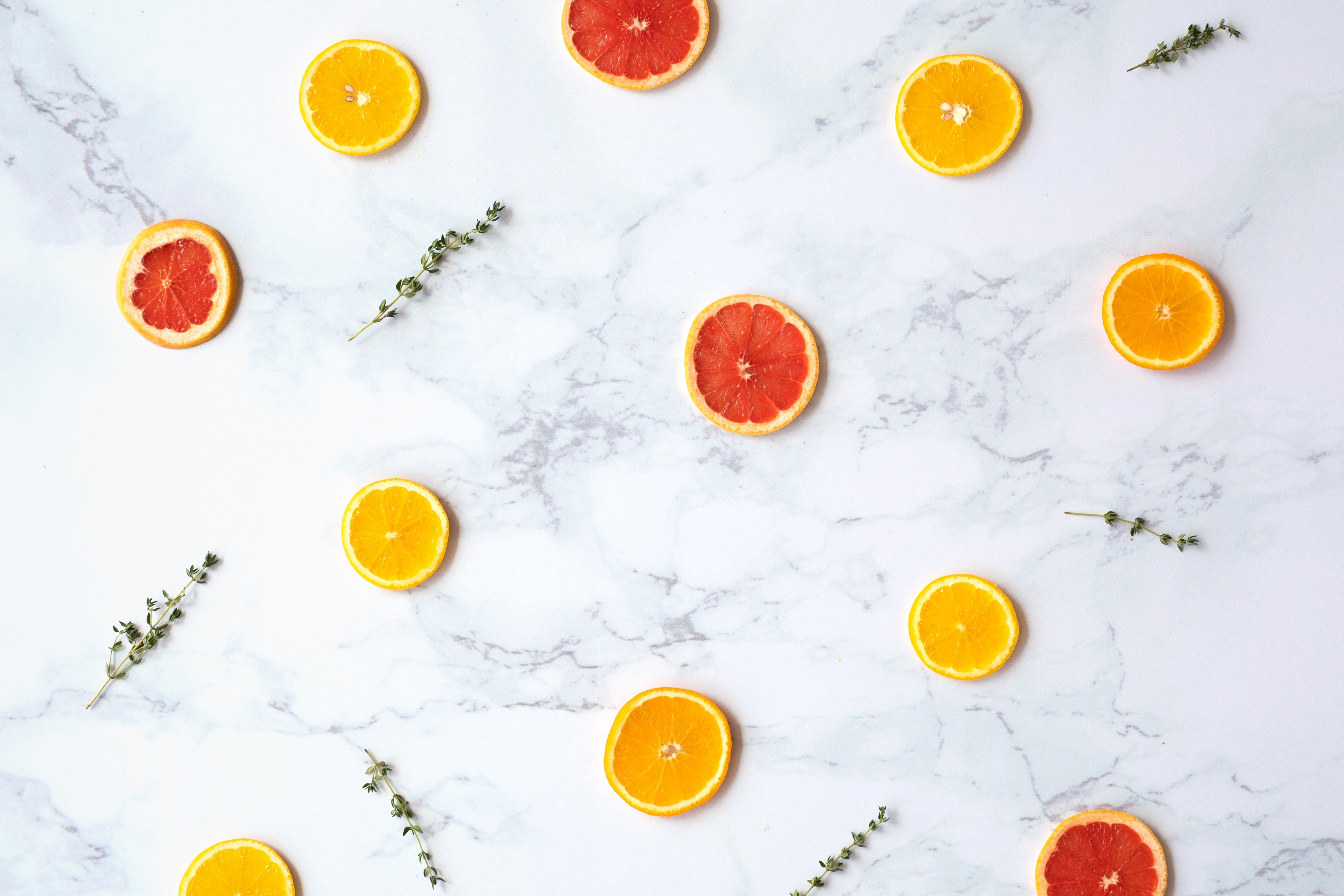 Flat lay photography of sliced citrus fruits on a marble surface