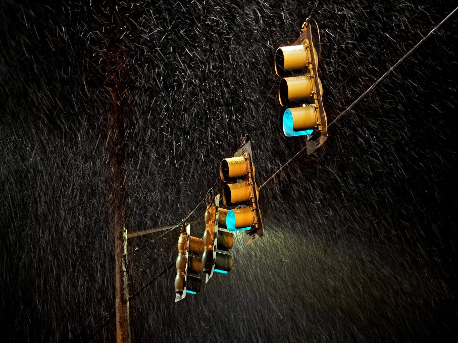 Four traffic lights under the rain during night time