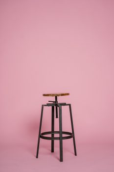 Metal stool in front of a pink background