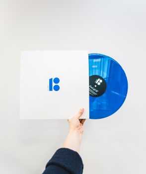 Minimalist photo of a person holding a blue vinyl record