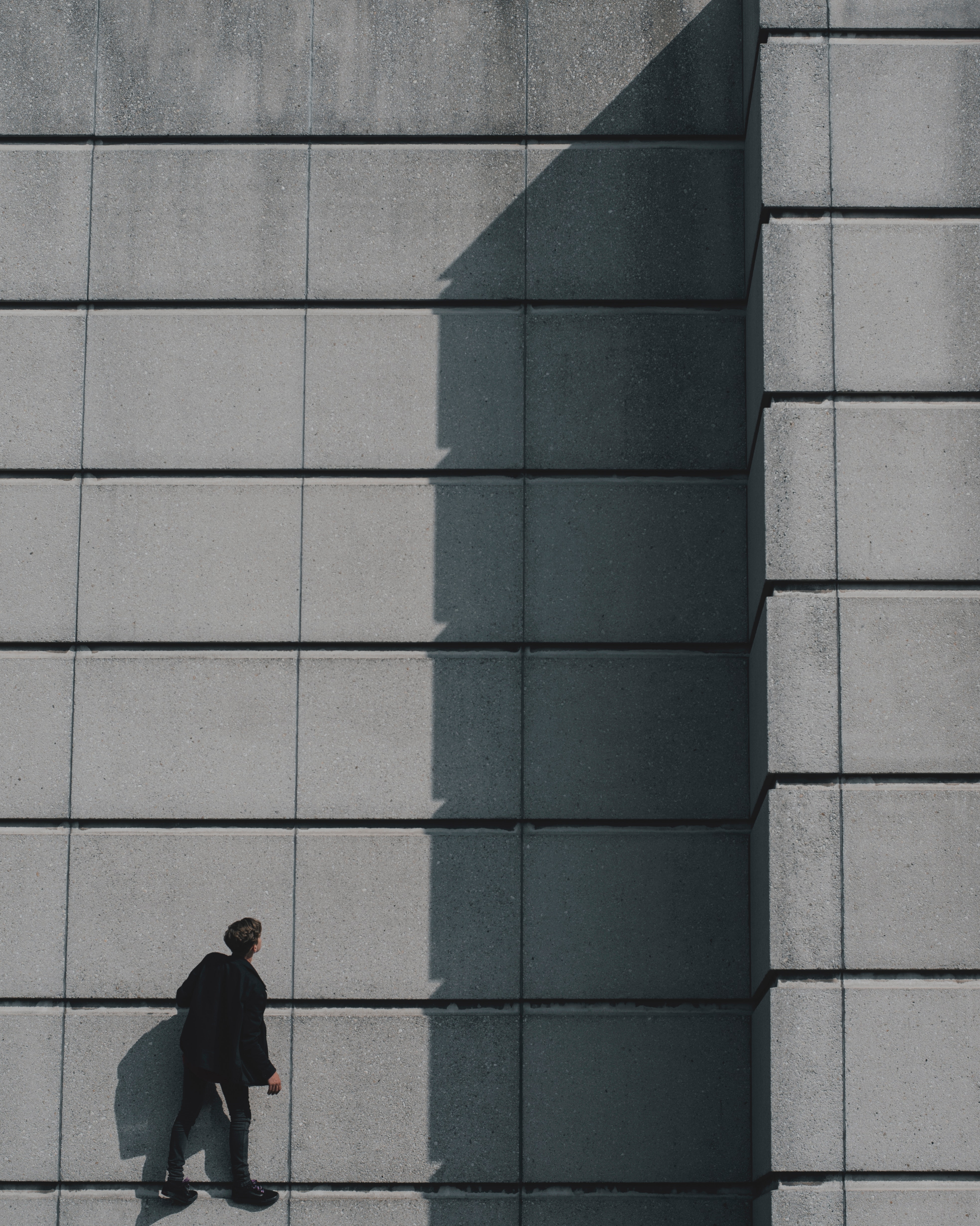 Photo of a man standing on a concrete building