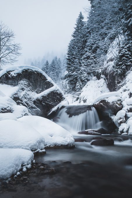 Photo of a waterfall in a snowy forest