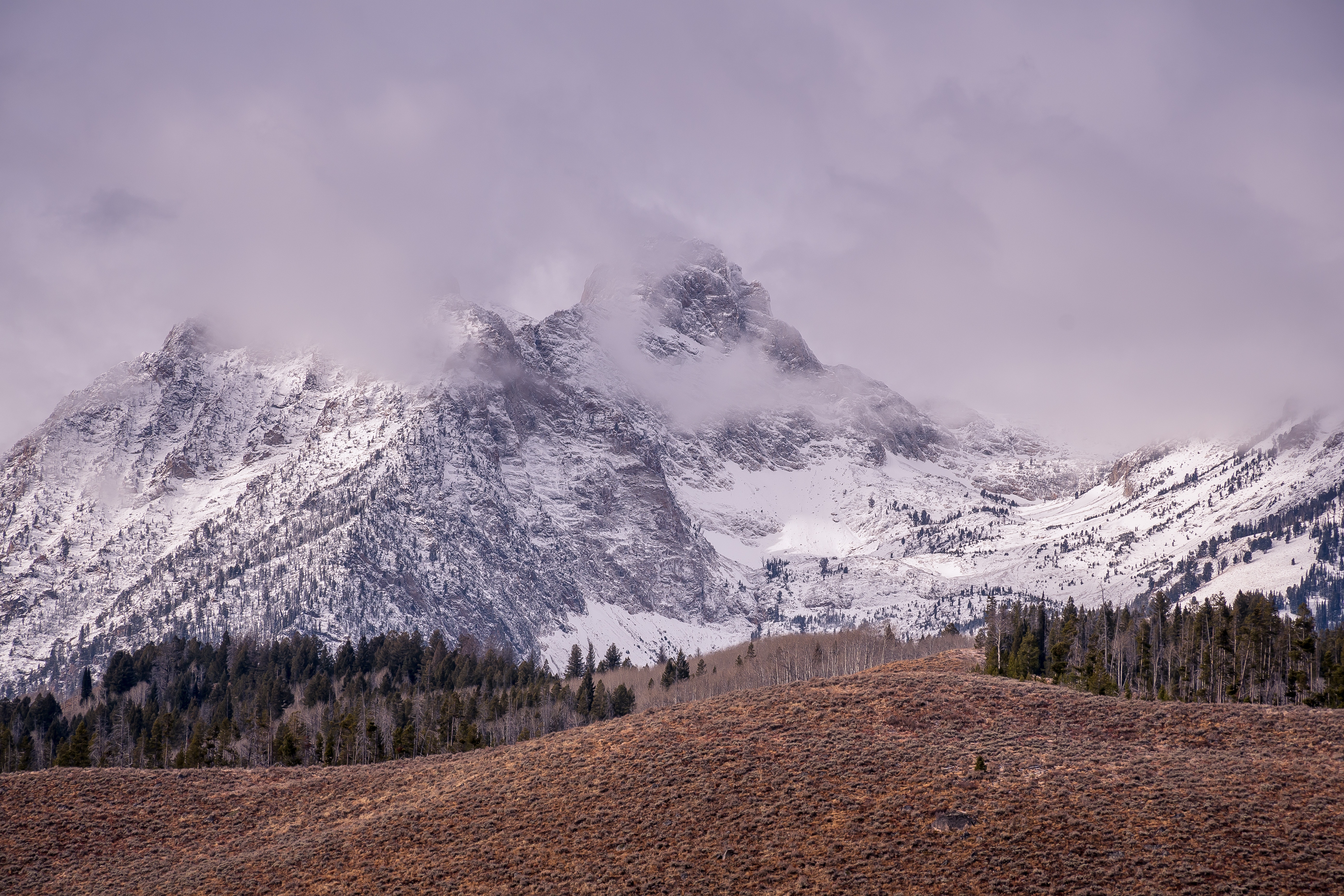 Photo of a snowy mountain under gray clouds