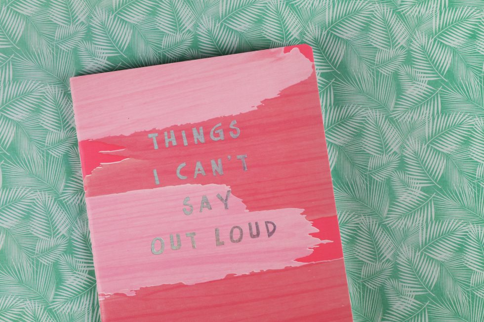 “Things I can't say out loud” book lying on a green textile