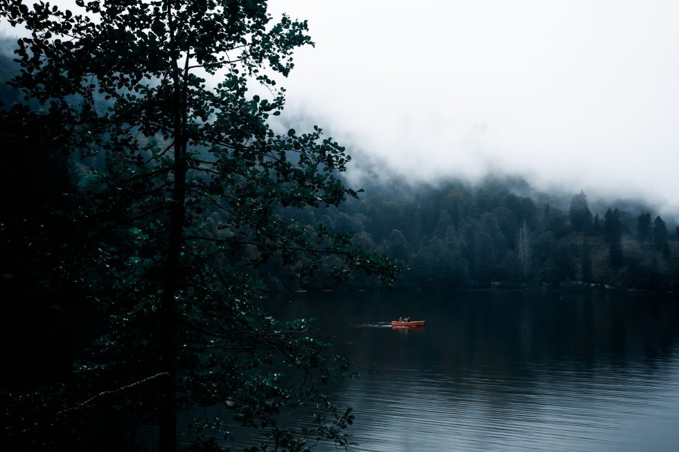A boat floating on a lake in the fog