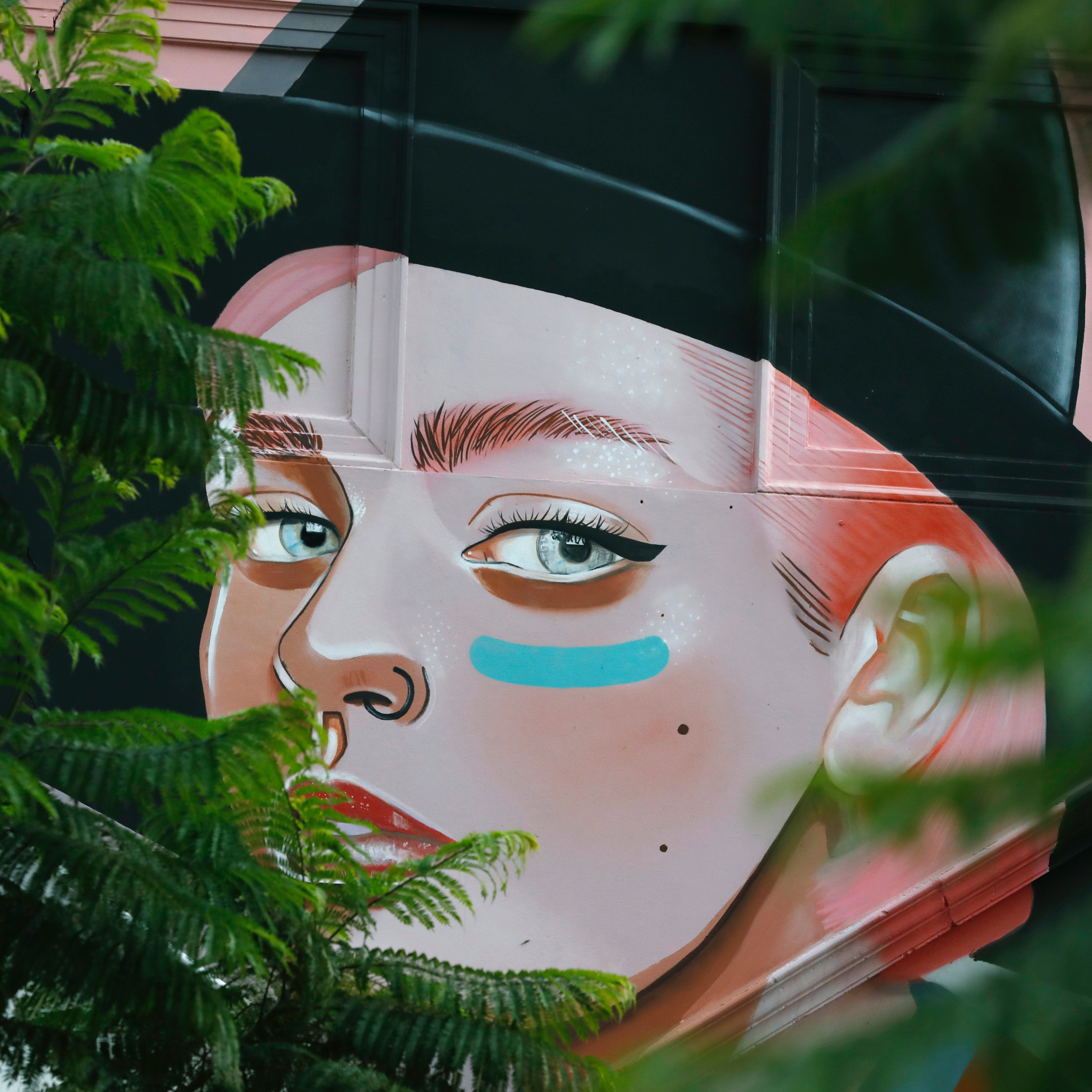 A colorful mural of a woman wearing black hat