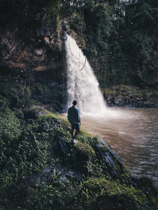 A man standing beside waterfalls