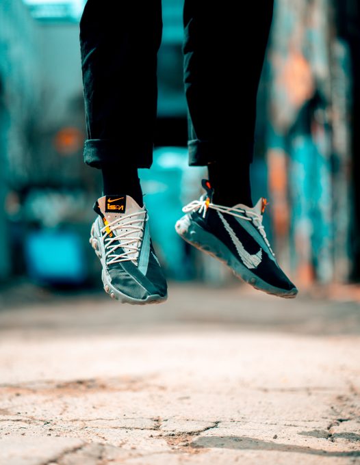 A person in Nike sneakers hovering above the ground