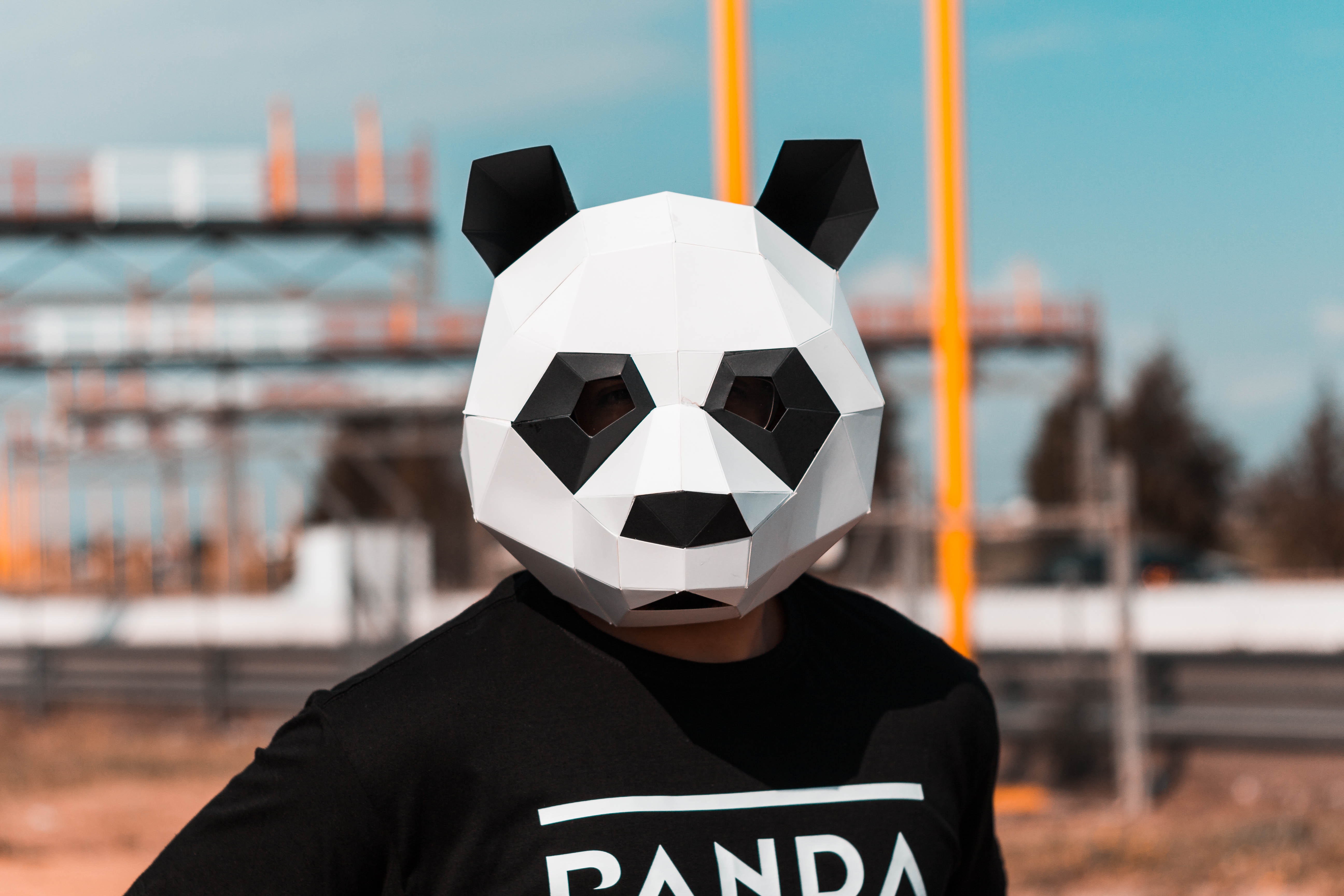 A person wearing a white and black panda full-face mask