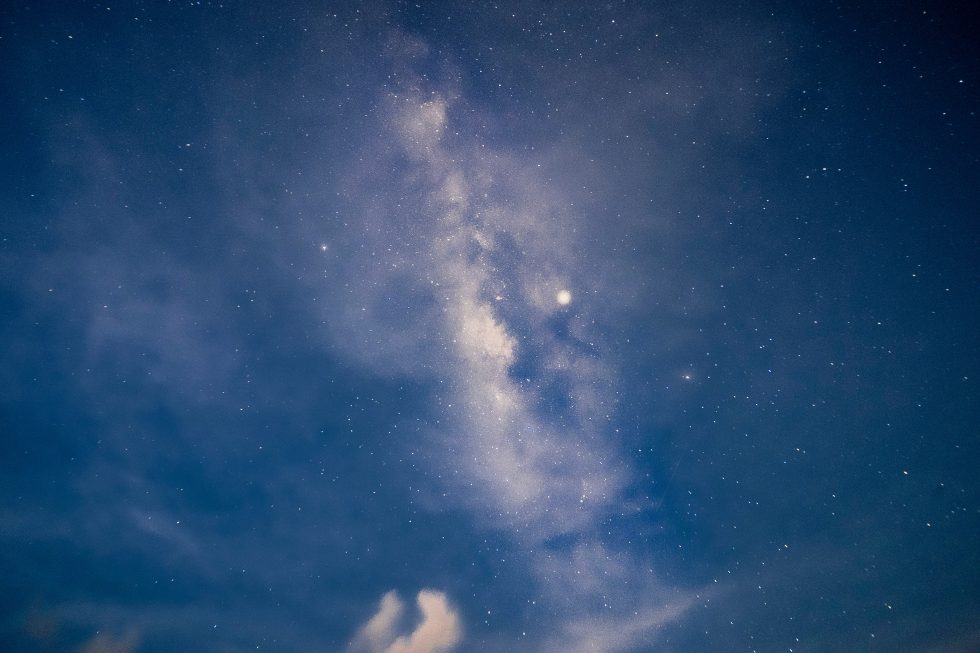A starry night sky with white clouds