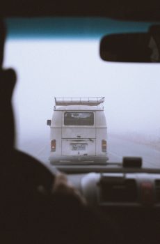 A white vehicle driving in fog