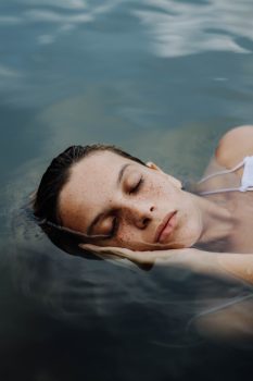 A woman sleeping on the body of water